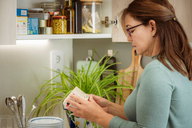 Woman reading a nutrition label in the kitchen